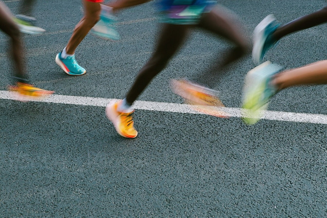 Runners in colorful racing shoes on a road