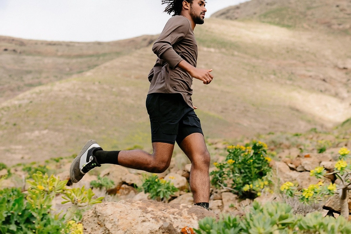 Trail runner running on a rocky hillside trail